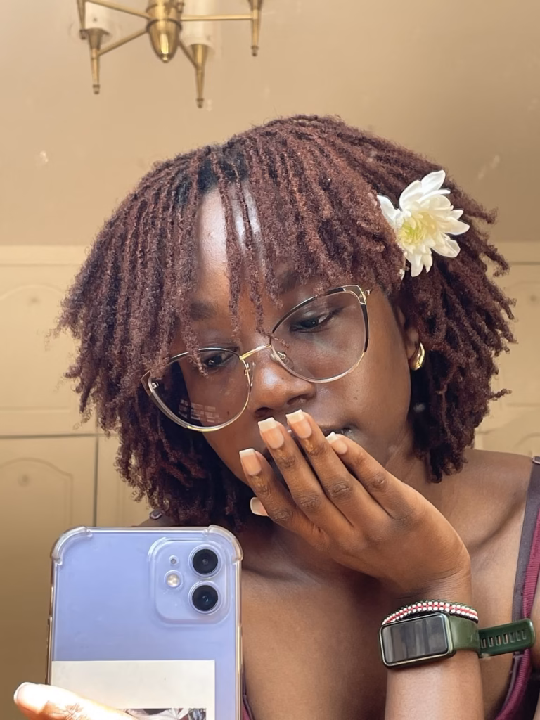 Short Reddish Brown Locs With Gold Butterfly Frames and a Flower