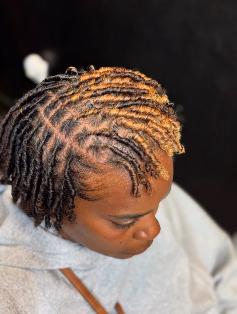 Position the clip slightly back from the crown so the curly burst at the top has room to fan forward naturally.Two-Tone Starter Locs with Sweeping Honey Blonde CrownColor placement this intentional at the starter stage is rare and it pays off immediately.